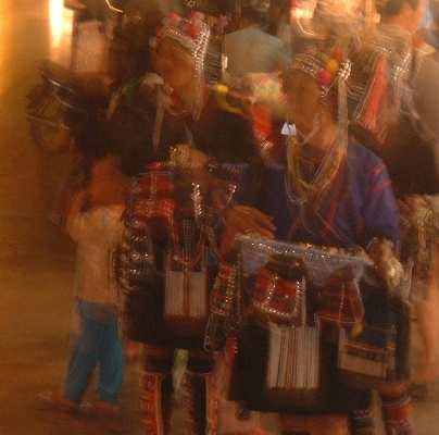 ARTSY SHOT, OR LUCKY MISTAKE?   Whatever, this blurry shot of some Akha women (and child), on a busy Chiang Mai street at night, has a sort of, well, QUALITY to it... doesn't it?!    :=)