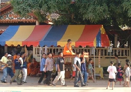 A procession at Pha That Luang:  carrying a monk, round and round...