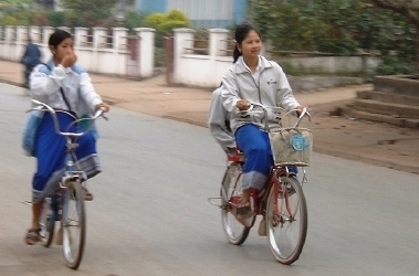 Young Lao women, or school girls, zipping along on their bikes