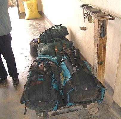 Our backpacks, being weighed at the Phonsavan airport--the old fashioned way